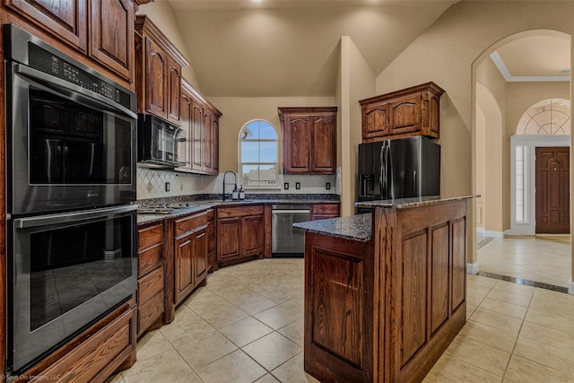 477 Horseshoe Bnd, Royse City, TX 75189 - kitchen with stainless steel appliances, a center island, light tile patterned flooring, lofted ceiling, and arched walkways