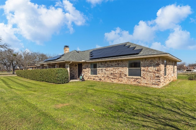 101 Hill Top Cir, Burleson, TX 76028 - rear view of property featuring roof mounted solar panels, a chimney, a yard, roof with shingles, and brick siding