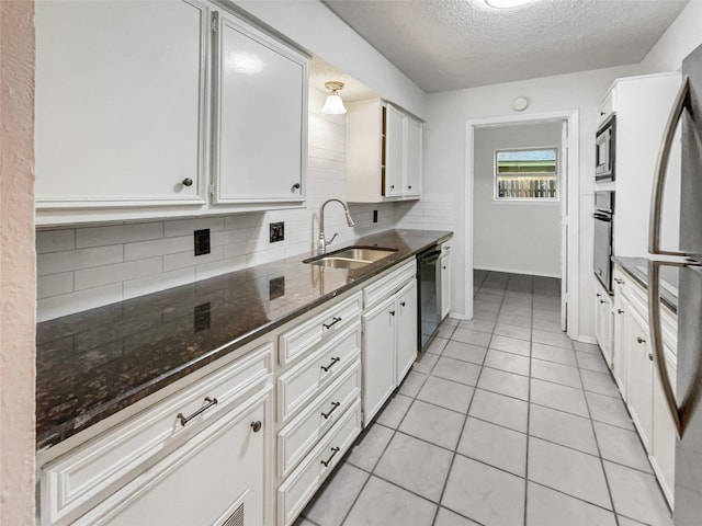925 Old Mill Cir, Irving, TX 75061 - kitchen with a sink, tasteful backsplash, black appliances, a textured ceiling, and white cabinets