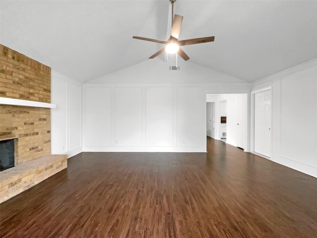 925 Old Mill Cir, Irving, TX 75061 - unfurnished living room featuring lofted ceiling, a decorative wall, ceiling fan, a fireplace, and wood finished floors