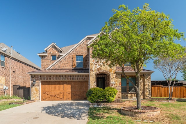 view of front of home with concrete driveway, a standing seam roof, stone siding, and metal roof