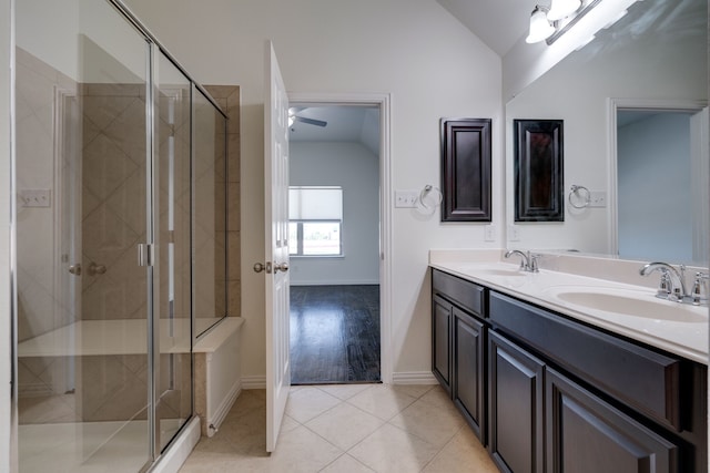 bathroom featuring a sink, a stall shower, tile patterned flooring, and vaulted ceiling