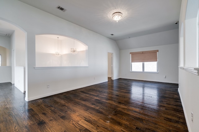 spare room with visible vents, baseboards, arched walkways, dark wood finished floors, and vaulted ceiling