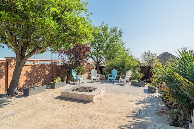 view of patio featuring an outdoor fire pit and a fenced backyard