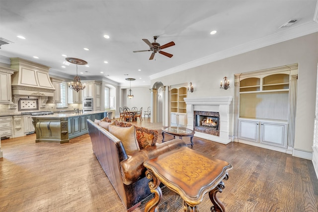 2909 Canyon Creek Dr, Sherman, TX 75092 - living area with ceiling fan, light wood finished floors, ornamental molding, a lit fireplace, and recessed lighting