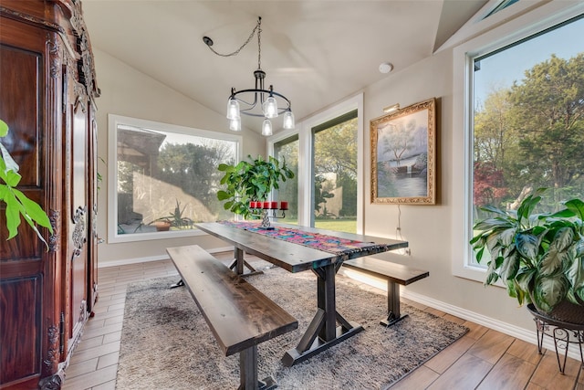 dining area featuring baseboards, an inviting chandelier, wood finished floors, and lofted ceiling