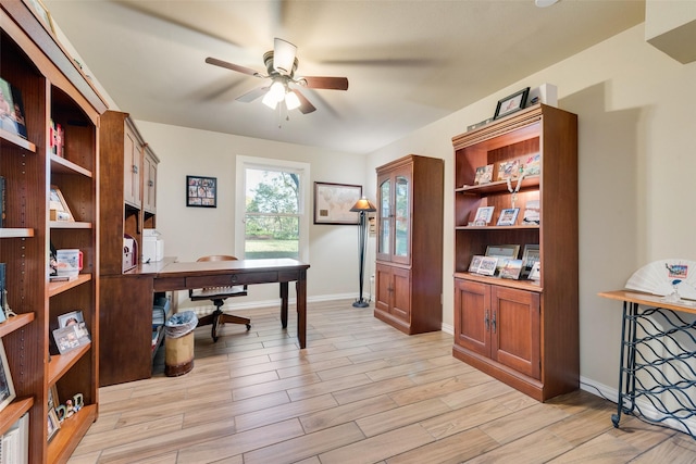 office space featuring baseboards, light wood-type flooring, and a ceiling fan