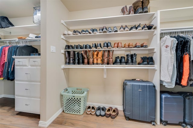 walk in closet with wood finished floors