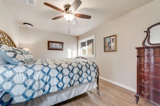 bedroom featuring visible vents, baseboards, light wood finished floors, and a ceiling fan