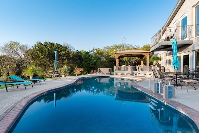 outdoor pool with a gazebo and a patio area