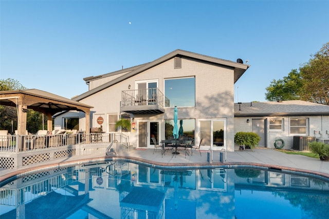 pool featuring a patio, a gazebo, and cooling unit