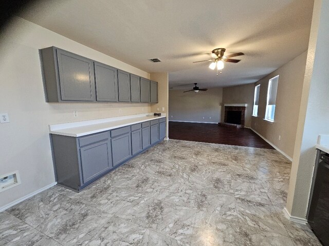 1416 Connie St, Burleson, TX 76028 - kitchen featuring gray cabinets, a fireplace, baseboards, and ceiling fan