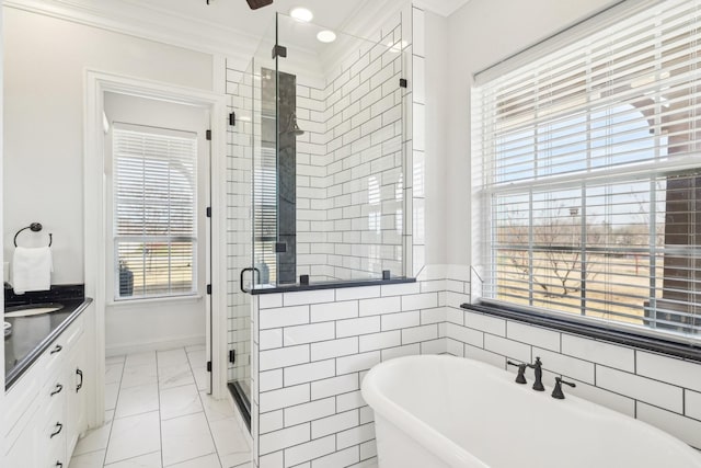 bathroom with vanity, a shower stall, marble finish floor, a freestanding bath, and ornamental molding