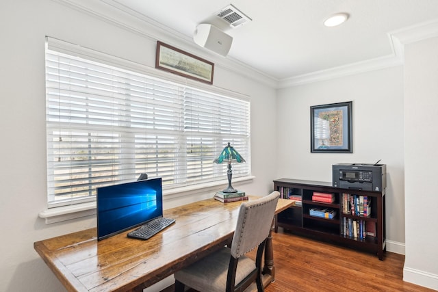 office area featuring wood finished floors, ornamental molding, baseboards, and visible vents
