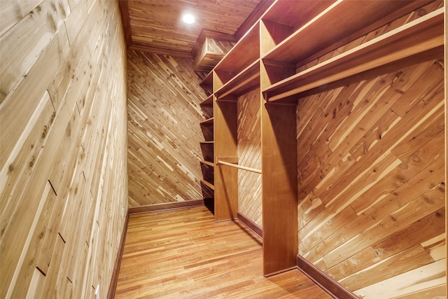 walk in closet with wood finished floors