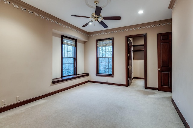 unfurnished bedroom featuring crown molding, a walk in closet, carpet floors, recessed lighting, and baseboards