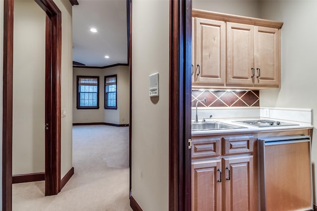 bar with backsplash, crown molding, a sink, carpet floors, and baseboards