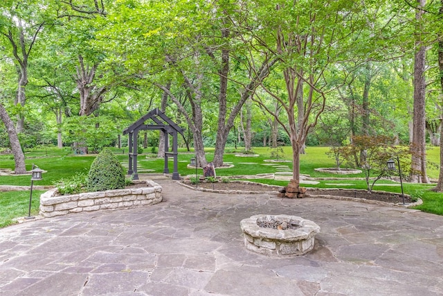 view of property's community featuring a yard and an outdoor fire pit