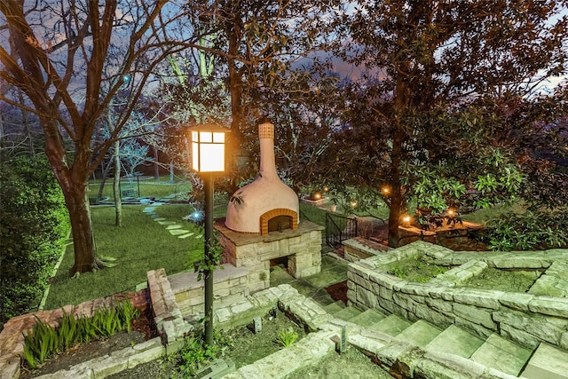 view of yard featuring an outdoor stone fireplace