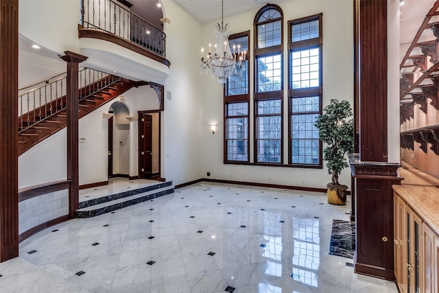 entryway with baseboards, a high ceiling, and a chandelier