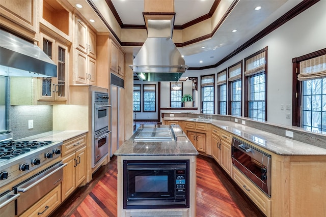 kitchen featuring under cabinet range hood, stainless steel appliances, a spacious island, and ornamental molding