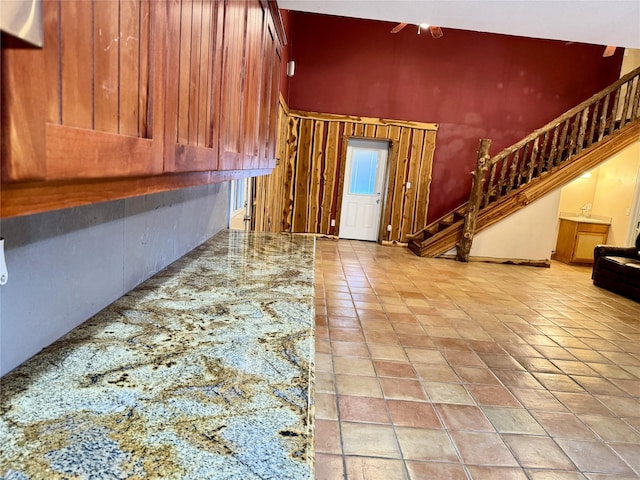interior space featuring light tile patterned floors, stairway, and a high ceiling