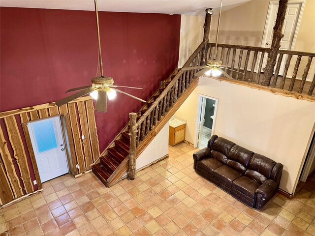 staircase featuring a ceiling fan and a towering ceiling