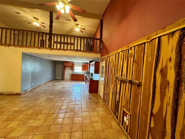 interior space with open floor plan, visible vents, a high ceiling, and ceiling fan