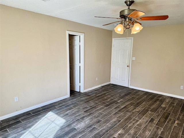 empty room with baseboards, a ceiling fan, and wood tiled floor
