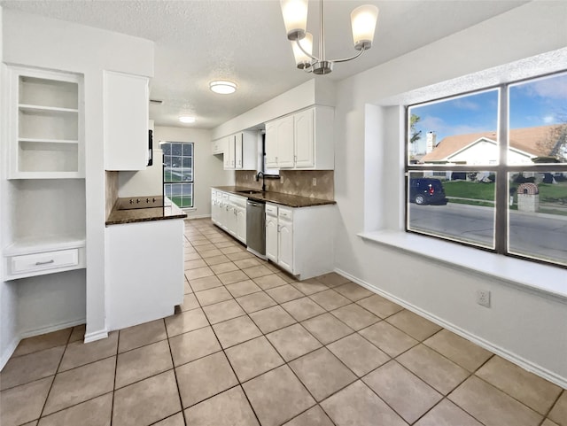 kitchen with dark countertops, white cabinets, light tile patterned floors, decorative backsplash, and dishwasher