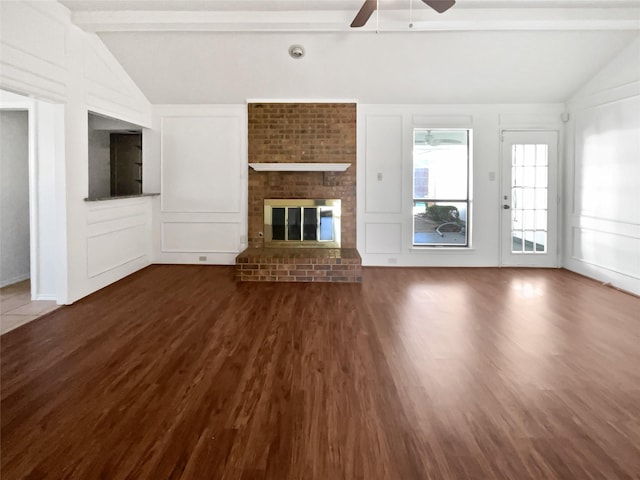 unfurnished living room featuring dark wood-type flooring, a decorative wall, vaulted ceiling with beams, and a ceiling fan