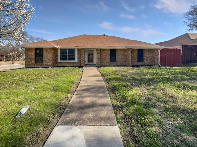 ranch-style home with a front yard, fence, and brick siding