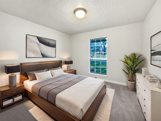 carpeted bedroom with baseboards and a textured ceiling