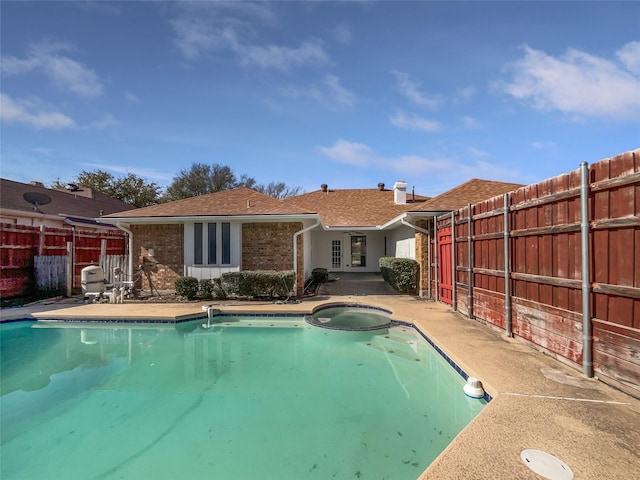 view of pool featuring a patio, a pool with connected hot tub, and fence
