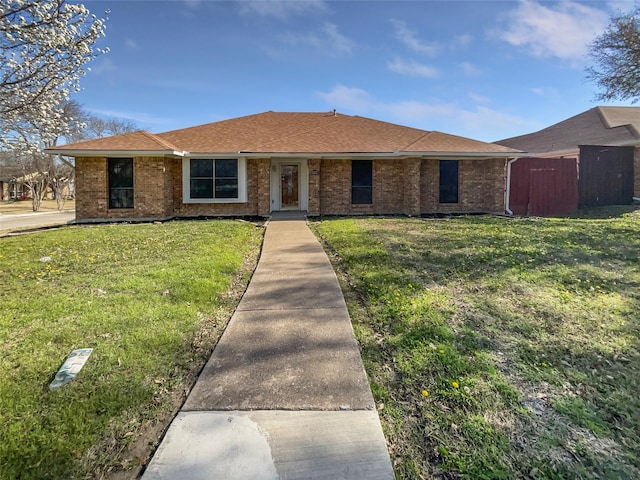 ranch-style house featuring brick siding and a front lawn