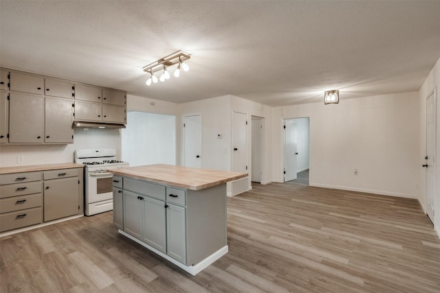 411 N 5th Ave, Munday, TX 76371 - kitchen with white gas range, wooden counters, a textured ceiling, and light wood-style floors