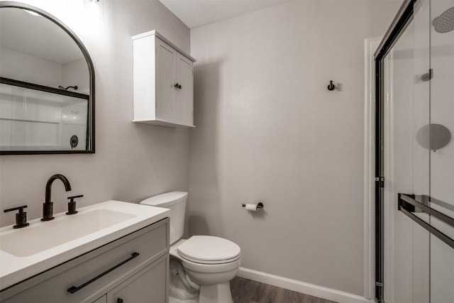 411 N 5th Ave, Munday, TX 76371 - bathroom with wood finished floors, toilet, a stall shower, and vanity