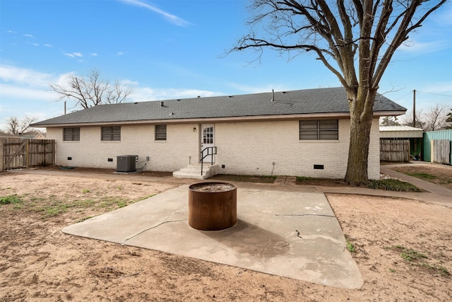 411 N 5th Ave, Munday, TX 76371 - back of house with cooling unit, fence, crawl space, a patio area, and brick siding