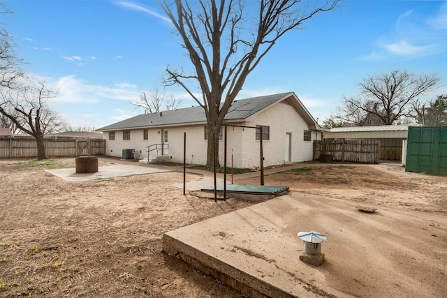 411 N 5th Ave, Munday, TX 76371 - rear view of house with central air condition unit, brick siding, a fenced backyard, and a patio area