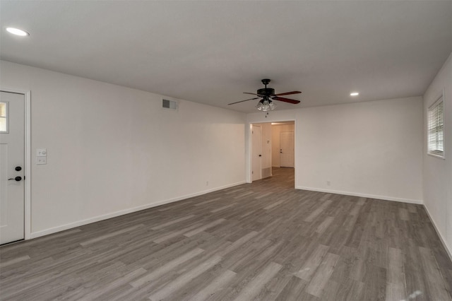 411 N 5th Ave, Munday, TX 76371 - unfurnished living room with visible vents, wood finished floors, recessed lighting, baseboards, and ceiling fan