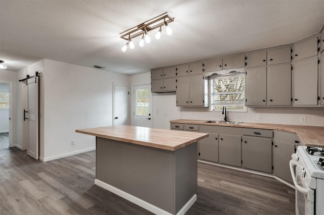 411 N 5th Ave, Munday, TX 76371 - kitchen featuring dark wood-style floors, visible vents, wooden counters, gas range gas stove, and a sink