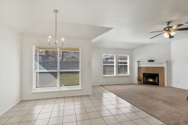 unfurnished living room featuring light tile patterned floors, baseboards, a fireplace, ceiling fan with notable chandelier, and light colored carpet