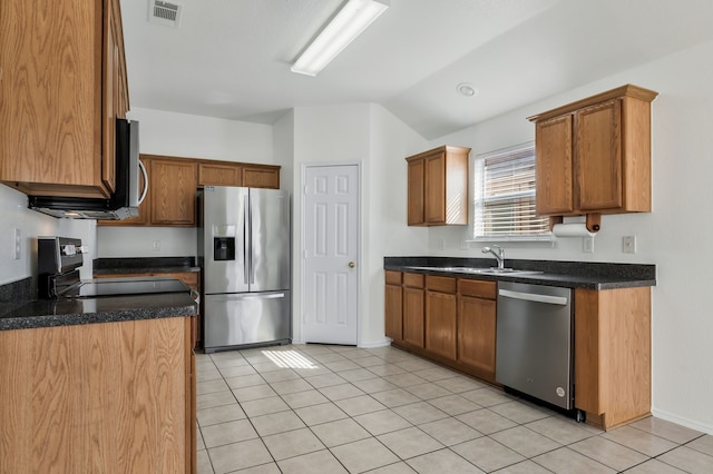 kitchen featuring dark countertops, visible vents, lofted ceiling, light tile patterned floors, and appliances with stainless steel finishes