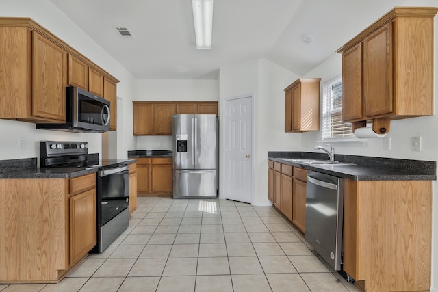 kitchen featuring visible vents, a sink, dark countertops, appliances with stainless steel finishes, and light tile patterned flooring