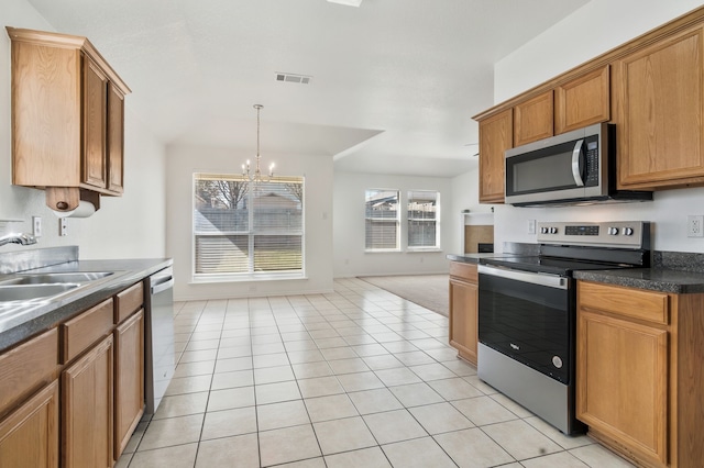 kitchen featuring visible vents, a notable chandelier, a sink, dark countertops, and stainless steel appliances