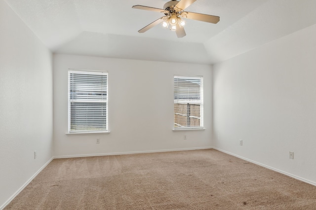 spare room with baseboards, lofted ceiling, light colored carpet, and a ceiling fan