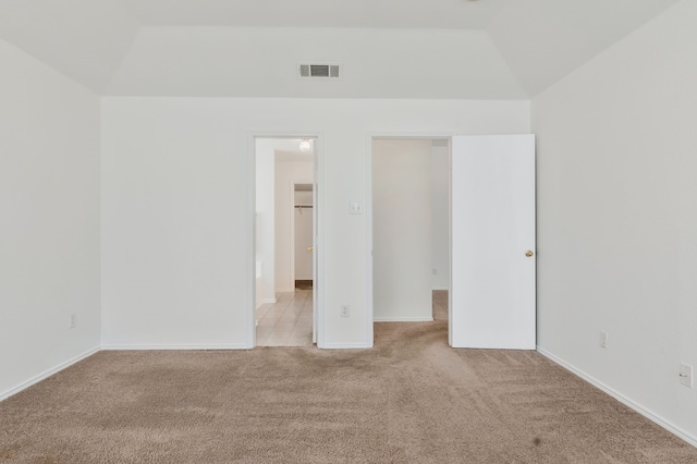 interior space with vaulted ceiling, carpet flooring, and visible vents