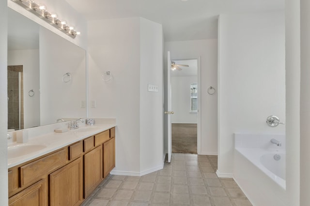 full bathroom with tile patterned floors, a tub to relax in, a ceiling fan, a sink, and double vanity