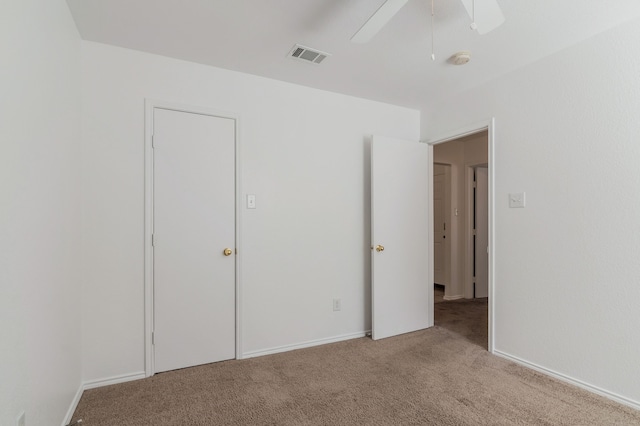 unfurnished bedroom with a ceiling fan, light colored carpet, and visible vents