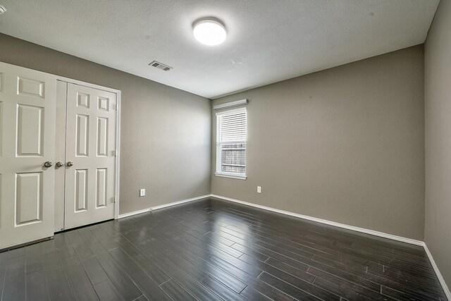 2444 Horseback Trl, Fort Worth, TX 76177 - unfurnished bedroom with baseboards, dark wood finished floors, a closet, and a textured ceiling